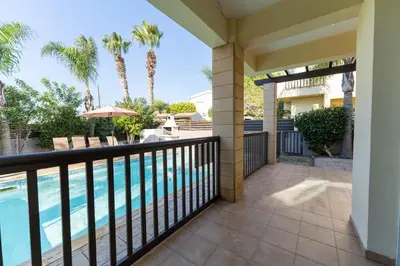 a balcony with a swimming pool and palm trees at Villa Lynn Chill Out Seaview in Ayia Napa
