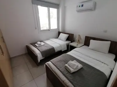 a hotel room with two beds and a window at Must Stay - City Center in Larnaka