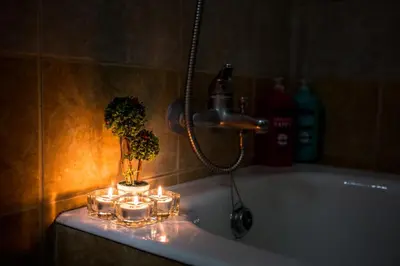 a bathroom with a tub with candles and a plant at Yippee! Apartments I Town Center in Larnaka