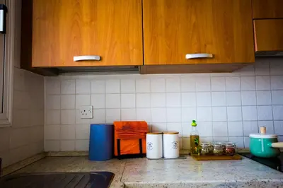 a kitchen with wooden cabinets and a counter top at Yippee! Apartments I Town Center in Larnaka