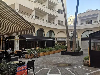 a courtyard with tables and chairs in a building at Yippee! Apartments I Town Center in Larnaka