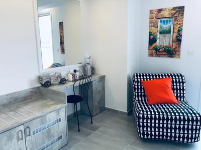a room with a chair and a desk with a red pillow at White 11 in Larnaka