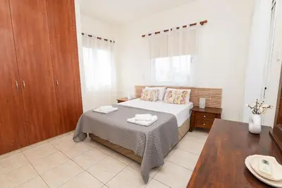 a bedroom with a bed and a table in it at Konnos Villa Ekaterina in Protaras