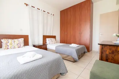 a bedroom with two beds and a dresser at Konnos Villa Ekaterina in Protaras