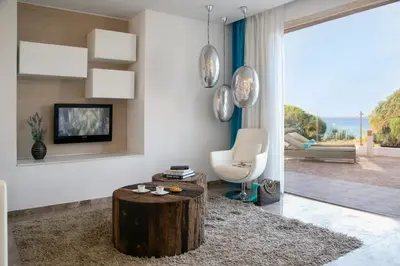 a living room with a tree stump coffee table and a television at Althea Kalamies Luxury Villas in Protaras