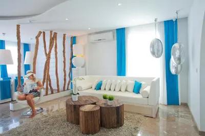 a woman sitting on a couch in a living room at Althea Kalamies Luxury Villas in Protaras