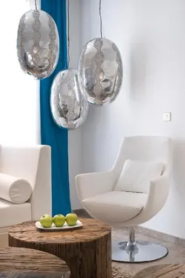 a living room with a white chair and a table at Althea Kalamies Luxury Villas in Protaras