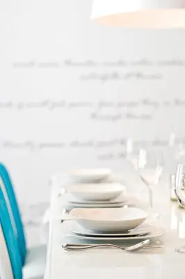 a row of white plates and silverware on a table at Althea Kalamies Luxury Villas in Protaras