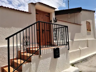 a white building with a staircase with a wooden door at Lemon Tree Courtyard in Larnaka