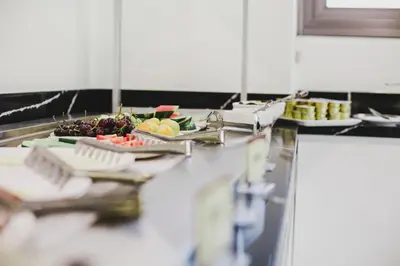 a buffet line with plates of fruits and vegetables at Frangiorgio Hotel in Larnaka