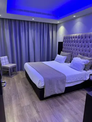 a bedroom with a large bed with a purple ceiling at Frangiorgio Hotel in Larnaka