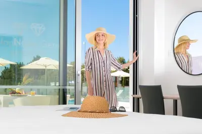 a woman in a straw hat standing next to a table at NAPA GEM SUITES by LUXEL VILLAS in Ayia Napa