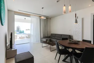 a living room with a table and a couch at NAPA GEM SUITES by LUXEL VILLAS in Ayia Napa