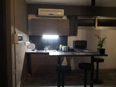 a small kitchen with a sink and two bar stools at The room in Larnaka