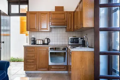 a kitchen with wooden cabinets and a microwave at Aunt Maria's in Pano Lefkara