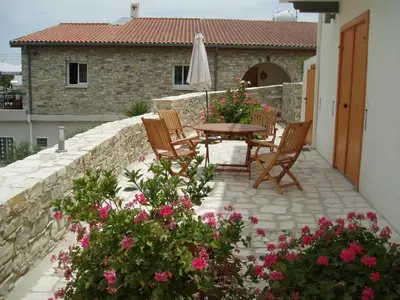 a patio with a table and chairs and flowers at Aunt Maria's in Pano Lefkara