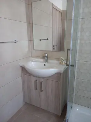a bathroom with a sink and a mirror and a shower at Proteas Mare Suites in Protaras