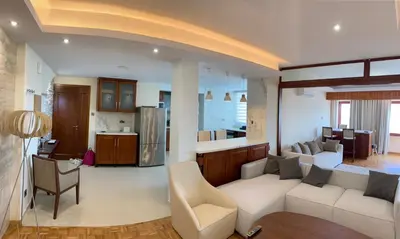 a living room with a couch and a kitchen at Modern 2 bed room large apartment in Nicosia