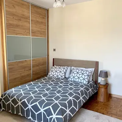 a bedroom with a bed with a wooden headboard at Modern 2 bed room large apartment in Nicosia
