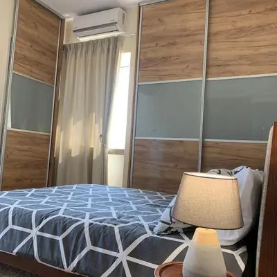 a bedroom with a bed and a table with a lamp at Modern 2 bed room large apartment in Nicosia