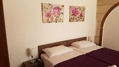 a bedroom with a bed and two pictures on the wall at ZORBAS No 3 in Larnaka