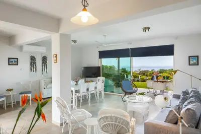 a living room with a couch and a table at Protaras Sirina Waterfront Villa in Protaras