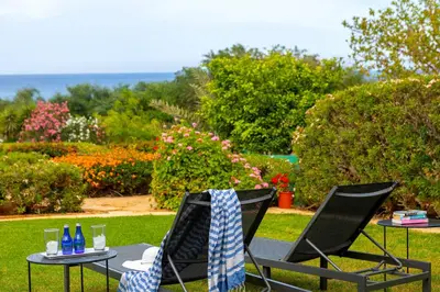 two chairs and a table with drinks on it at Protaras Sirina Waterfront Villa in Protaras