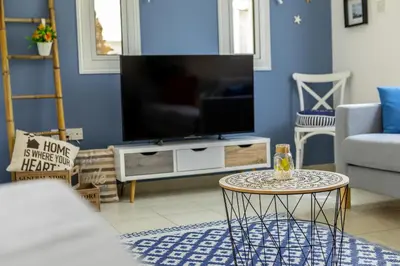 a living room with a tv and a table at Kalimera Villa Protaras in Protaras