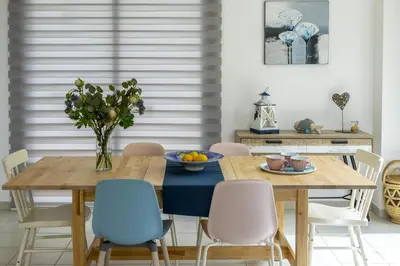 a dining room with a wooden table and chairs at Kalimera Villa Protaras in Protaras