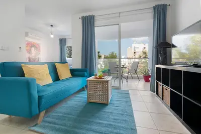 a living room with a blue couch and a table at Glabur Stays - The Cozy Atelier - Nicosia City, Free Parking & Wifi, Welcomes You!!! in Nicosia