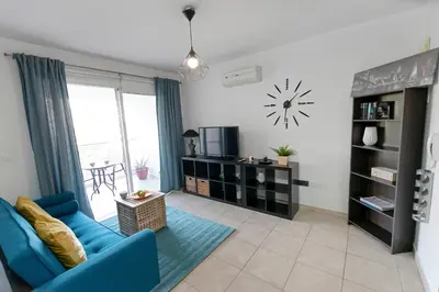 a living room with a blue couch and a clock on the wall at Glabur Stays - The Cozy Atelier - Nicosia City, Free Parking & Wifi, Welcomes You!!! in Nicosia
