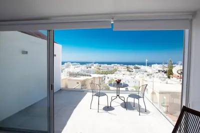 a balcony with a table and chairs and a view of the city at Rio Luxury Apartment in Ayia Napa