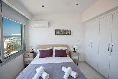 a bedroom with a large bed and a large window at Rio Luxury Apartment in Ayia Napa