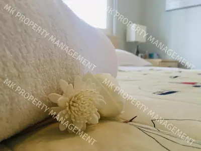 a pillow with a flower on top of a bed at Yiallos Village C107 in Larnaka