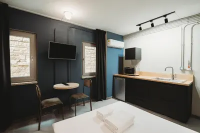 a kitchen with a sink and a counter with a table at eins rooms - city center in Limassol