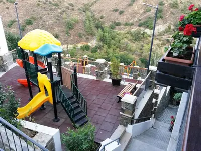 a playground with a slide and stairs on a balcony at Archontiko I Misirlou in Kalopanayiotis