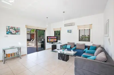 a living room with a couch and a tv at Villa To Perivoli in Protaras