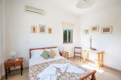 a bedroom with a bed and a table and a window at Villa To Perivoli in Protaras