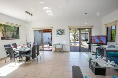 a living room with a table and chairs and a television at Villa To Perivoli in Protaras