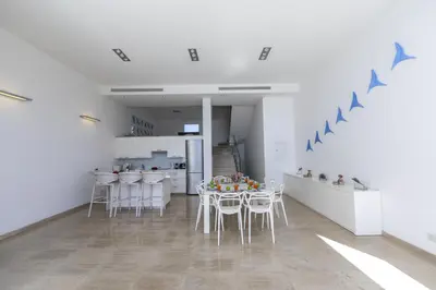 a room with a table and chairs and a kitchen at Protaras Villa Kalena Seafront in Protaras