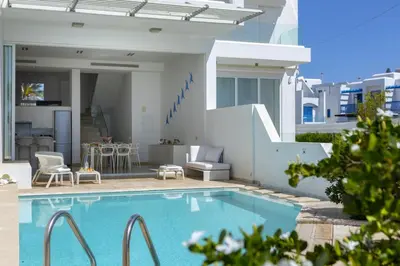 a swimming pool in front of a house at Protaras Villa Kalena Seafront in Protaras
