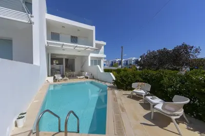 a swimming pool with chairs and a house at Protaras Villa Kalena Seafront in Protaras