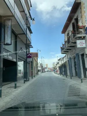 an empty street in a town with many shops at Tony’s Boutique Apartment in Larnaka