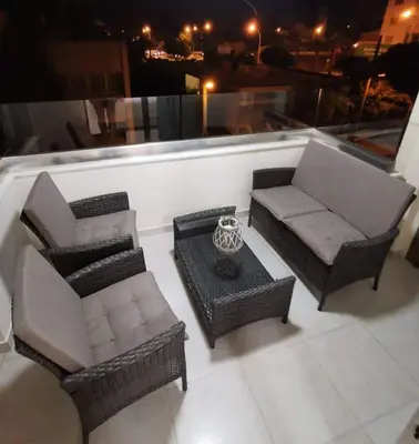 a balcony with a couch and chairs and a table at Tony’s Boutique Apartment in Larnaka