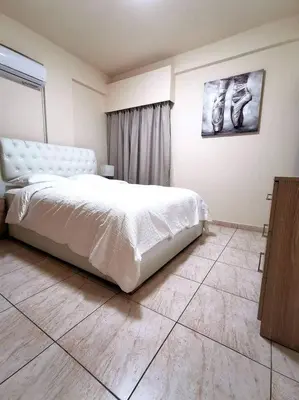 a bedroom with a white bed in a room at Tony’s Boutique Apartment in Larnaka