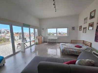 a living room with a couch and a bed at Limassol sea view studio in Limassol