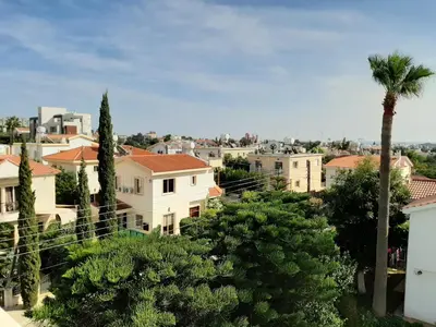a city with a palm tree and buildings at Limassol sea view studio in Limassol