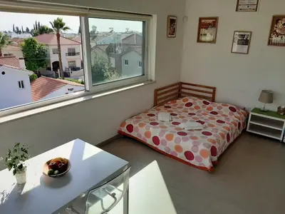 a bedroom with a bed and a large window at Limassol sea view studio in Limassol