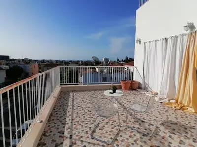 a balcony with a table and chairs on a roof at Limassol sea view studio in Limassol
