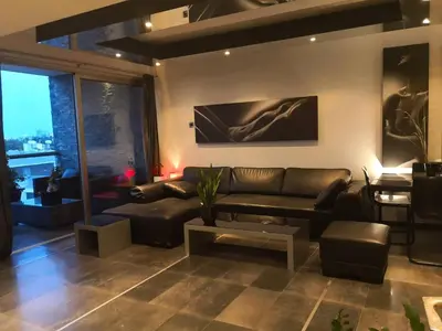 a living room with a leather couch and a table at Fine Designed Flat 302 in Larnaka
